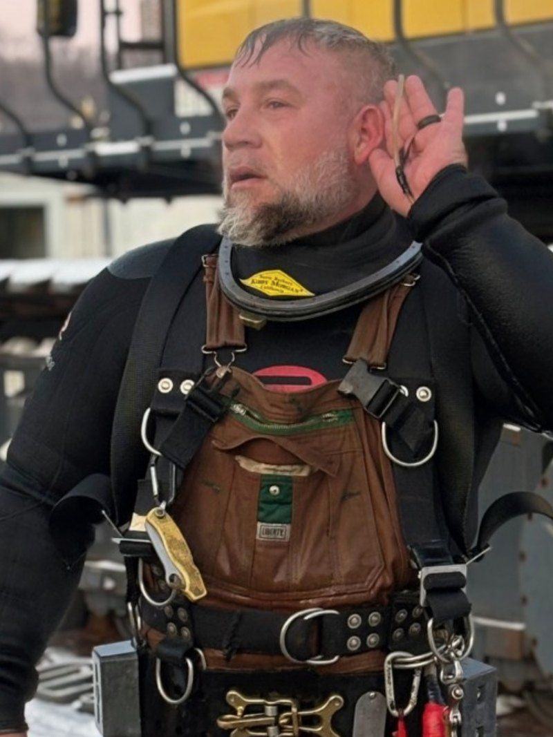 Blue Current commercial diver in harness and dry suit on the jobsite